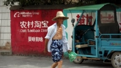 中國浙江桐廬一位農民走過淘寶的廣告牆。 （2015年7月20日）