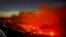 FILE - The Parker Lake wildfire glows in a photograph taken by a B.C. Emergency Health Services crew member through the window of an airplane evacuating patients from nearby Fort Nelson, British Columbia, Canada, May 10, 2024. 
