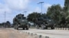 FILE - Somalia National Army (SNA) soldiers ride on an armored personnel carriers during a parade in Mogadishu, April 12, 2022.