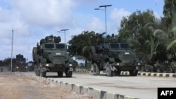 FILE - Somalia National Army (SNA) soldiers ride on an armored personnel carriers during a parade in Mogadishu, April 12, 2022.
