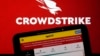The logo for CrowdStrike and a Spirit Airlines webpage are shown on a computer screen and mobile phone screen, in New York, July 19, 2024. 