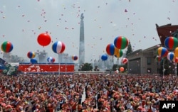 Dalam foto yang didistribusikan oleh lembaga negara Rusia Sputnik, warga menyambut kedatangan Presiden Rusia Vladimir Putin dan pemimpin Korea Utara Kim Jong Un dengan melepaskan balon ke udara di Lapangan Kim Il Sung, Pyongyang, 19 Juni 2024. (Vladimir SMIRNOV / POOL / AFP)