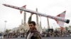 A Houthi supporter raises a mock rocket during a rally against the US and Israel and to support Palestinians in the Gaza Strip, in Sanaa, Yemen, April. 26, 2024. 