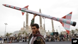 A Houthi supporter raises a mock rocket during a rally against the US and Israel and to support Palestinians in the Gaza Strip, in Sanaa, Yemen, April. 26, 2024. 