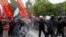 People react after riot police used tear gas during clashes, as protesters attempt to defy a ban and march on Taksim Square to celebrate May Day in Istanbul, May 1, 2024. 