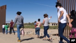 ARCHIVO - Un grupo de migrantes brasileños ingresan a Estados Unidos desde México por una brecha del muro fronterizo, en Yuma, Arizona, con el fin de solicitar asilo a las autoridades migratorias estadounidenses, el 8 de junio de 2021