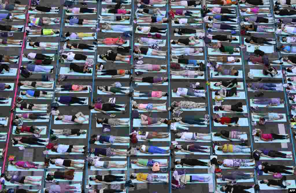 Orang-orang mengikuti acara tahunan yoga untuk merayakan titik balik matahari musim panas di Times Square, New York City, Kamis, 20 Juni 2024. (Foto: Timothy A. Clary/AFP)