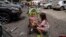 Children wait near the site of Okhmatdyt children’s hospital hit by Russian missiles, in Kyiv, Ukraine, Monday, July 8, 2024
