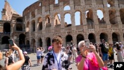 Visitors take photos of the Ancient Colosseum, in Rome, June 27, 2023. Italy's culture and tourism minister vowed to find and punish a tourist who was filmed carving his name and his girlfriend's name in the wall of the Colosseum.