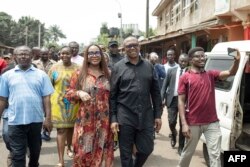 Labour Party (LP) presidential candidate Peter Obi (C) walks with his wife Margaret Brownson Obi walk in the street after casting their ballots at a polling station in Amatutu, southern Nigeria, Feb. 25, 2023,