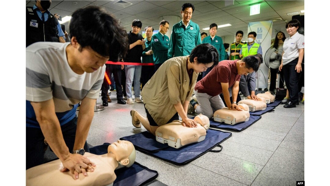 Wali Kota Seoul Oh Se-hoon (tengah atas) menyaksikan pelatihan CPR dengan menggunakan boneka peraga dalam rangka latihan pertahanan sipil melawan kemungkinan serangan artileri oleh Korea Utara, di stasiun kereta bawah tanah di Seoul, 23 Agustus 2023. (ANTHONY WALLACE / AFP)