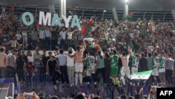 Players celebrate with supporters at the end of the final match of a football tournament at the municipal stadium in Idlib, Syria, Aug. 18, 2023.