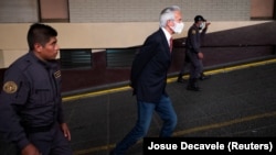 Journalist Jose Ruben Zamora Marroquin is escorted by prison guards after his court hearing in Guatemala