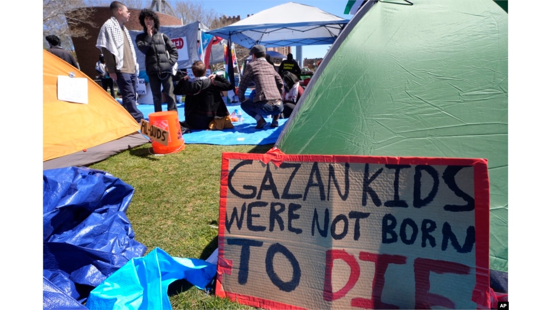 A sign calling attention to the conflict in Gaza rests against a tent, April 25, 2024, at an encampment on the Massachusetts Institute of Technology campus, in Cambridge, Mass.