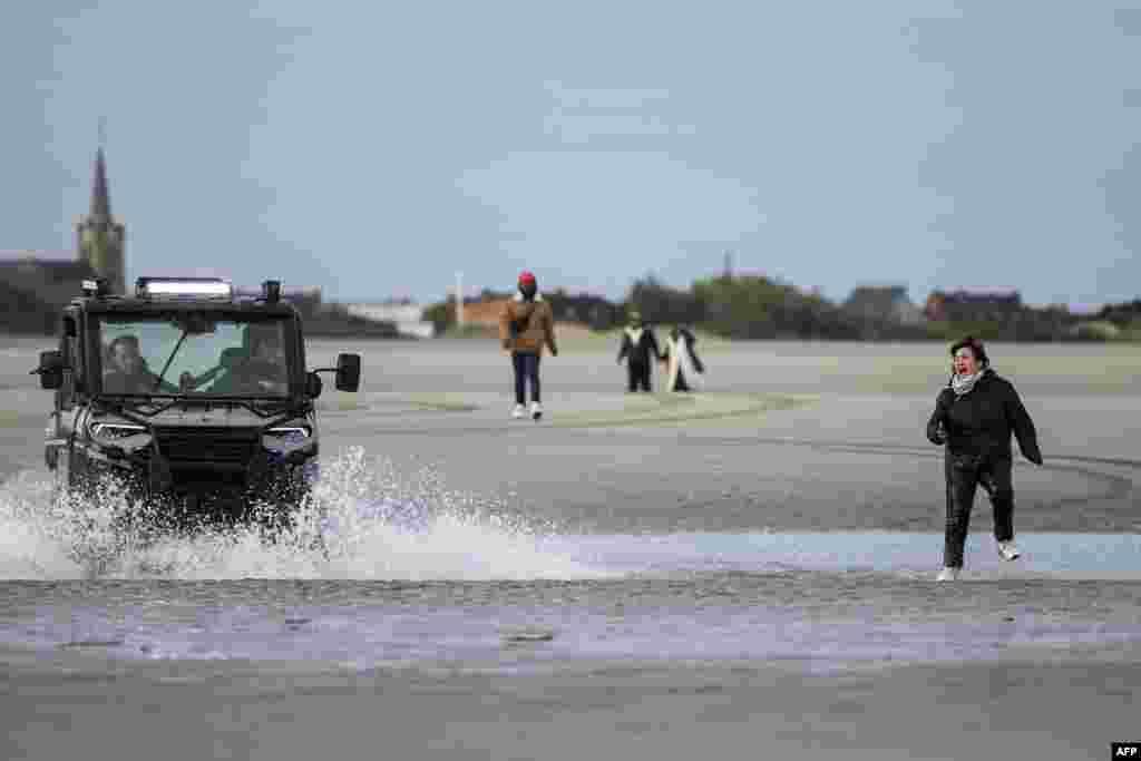 A migrant is chased by French police while attempting to board a smuggler's boat in an attempt to cross the English Channel, on the beach of Gravelines, near Dunkirk, northern France.