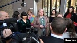 Transgender woman Roxanne Tickle, center, leaves the Federal Court of Australia in Sydney, Australia, Aug. 23, 2024. Tickle won a discrimination lawsuit against Giggle for Girls, a female-only social networking platform.