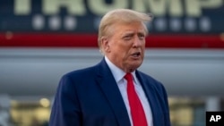 Former President Donald Trump speaks with reporters before departure from Hartsfield-Jackson Atlanta International Airport, Aug. 24, 2023, in Atlanta. 