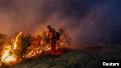 A firefighter battles the Sites fire near Lodoga, California, June 17, 2024.