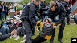 Police remove a protester from the 'Freie Universität Berlin' in Berlin, Germany, Tuesday, May 7, 2024. Pro-Palestinian activists occupied a courtyard of the Free University in Berlin on Tuesday. (AP Photo/Markus Schreiber)