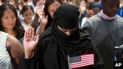 FILE - A participant from Bangladesh takes the Naturalization Oath of Allegiance to the United States of America, on June 30, 2017, during a naturalization ceremony at the New York Public Library in New York. (AP Photo/Michael Noble Jr.)