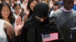 FILE - A participant from Bangladesh takes the Naturalization Oath of Allegiance to the United States of America, on June 30, 2017, during a naturalization ceremony at the New York Public Library in New York. (AP Photo/Michael Noble Jr.)