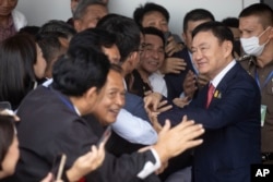 Thailand's former Prime Minister Thaksin Shinawatra, second right, is greeted by supporters on his arrival at Don Muang airport in Bangkok, Thailand, Aug. 22, 2023.