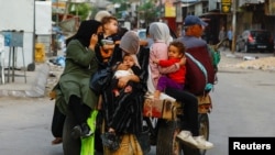 Palestinians flee their homes, amid Israeli strikes, in Khan Younis, southern Gaza Strip, Oct. 10, 2023.