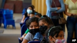 ARCHIVO - Niños esperan para vacunarse contra el COVID-19 en una escuela en Guayaquil, Ecuador, el martes 16 de noviembre de 2021. 