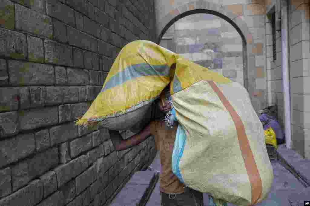 A boy carries a sack of goods at a popular market in Old Cairo, Egypt.