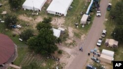 Migrants are seen at a processing center at Anzalduas Park near the Texas-Mexico border, May 12, 2023, in McAllen, Texas.