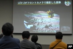 JAXA officials said Thursday that the spacecraft which landed Saturday, landed only about 55 meters away from its target set in between two craters near the Shioli crater, a region covered in volcanic rock. (AP Photo/Eugene Hoshiko)