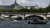 Polisi melakukan patroli dengan perahu di Sungai Seine dekat Grand Palais, sekitar 3 bulan sebelum dimulainya Olimpiade Paris 2024 di Paris. 
