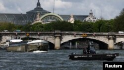 Polisi melakukan patroli dengan perahu di Sungai Seine dekat Grand Palais, sekitar 3 bulan sebelum dimulainya Olimpiade Paris 2024 di Paris. 