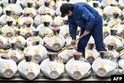 Seorang pekerja membersihkan sekitar tuna beku yang dipajang saat penjual grosir dan pembeli menghadiri lelang tuna pertama Tahun Baru di pasar ikan Toyosu, Tokyo,5 Januari 2024. (Richard A. Brooks / AFP)