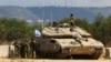 FILE - Israeli soldiers stand near to a tank near Israel's border with Lebanon in northern Israel, Oct. 16, 2023. Israel said on Nov. 3, 2024, that it launched a ground raid into Syria.