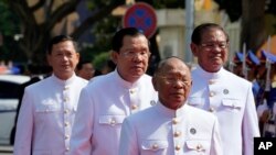 President of the National Assembly Heng Samrin, front, walks together with, Deputy Prime Minister and Minister of Interior Ministry Sar Kheng, right, Prime Minister Hun Sen, center, and Hun Manet, left, at the National Assembly in Phnom Penh, Cambodia, Monday, Aug. 21, 2023.