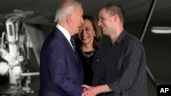 FILE - President Joe Biden, from left, and Vice President Kamala Harris greet reporter Evan Gershkovich at Andrews Air Force Base, Md., following his release as part of a 24-person prisoner swap between Russia and the United States, Aug. 1, 2024.