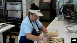 An employee makes pretzels at an Auntie Anne's and Cinnabon store in Livermore, Calif., March 28, 2024.