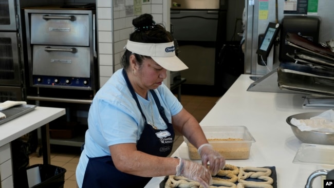 An employee makes pretzels at an Auntie Anne's and Cinnabon store in Livermore, Calif., March 28, 2024.