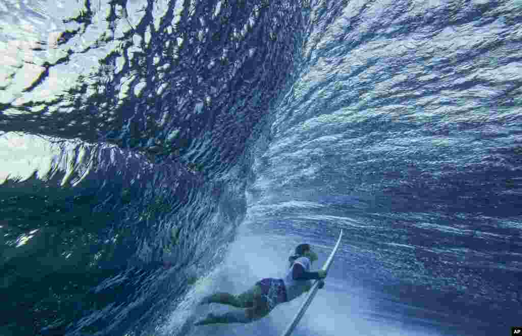 Brisa Hennessy of Costa Rica duck-dives a wave in the women&#39;s surfing bronze medal final of the surfing competition at the 2024 Summer Olympics, Aug. 5, 2024, in Teahupo&#39;o, Tahiti.