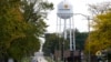 FILE - A pedestrian in Benton Harbor, Mich., crosses the street on Oct. 22, 2021, near the city's water tower. The U.S. is taking steps to better protect public drinking water and sewer systems from cyberattacks. 