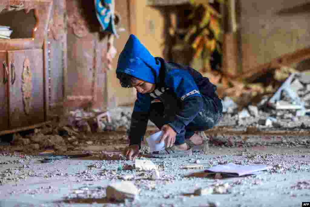 A Palestinian boy collects small pieces of debris following Israeli bombardment in Rafah in the southern Gaza Strip.