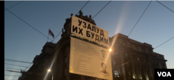 Transparent sa odštampanim stihovima peste "Uzalud ih budim" pesnika Branka Miljkovića, u rukama učesnika 19. protesta Srbija protiv nasilja, ispred zgrade Vlade Srbije, u Beogradu, 8. septembra 2023. (Foto: Glas Amerike/Stefan Miljuš)