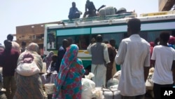 FILE: People board a bus to leave Khartoum, June 3, 2023, as fighting between the Sudanese Army and paramilitary Rapid Support Forces intensified. Fighting continued Monday in Khartoum along with looting.
