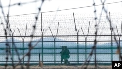 FILE - South Korean army soldiers patrol along the barbed-wire fence in Paju, South Korea, near the border with North Korea, Feb. 16, 2023. 