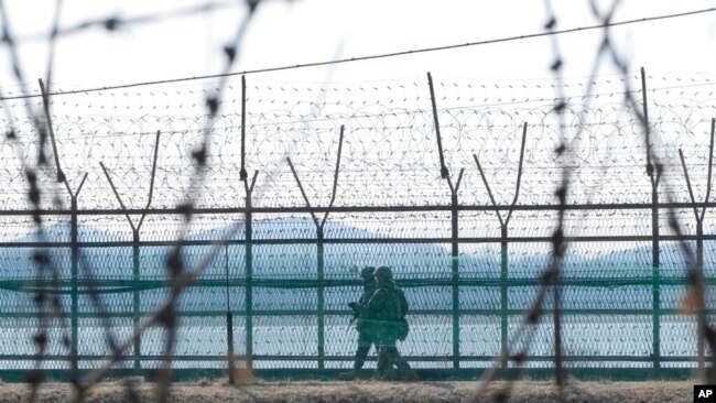 FILE - South Korean army soldiers patrol along the barbed-wire fence in Paju, South Korea, near the border with North Korea, Feb. 16, 2023.