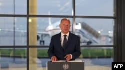 Njemački kancelar Olaf Scholz razgovara s novinarima na aerodromu Keln/Bonn u Njemačkoj, 1. avgusta 2024., nakon što su njemački politički zatvorenici pušteni na slobodu u jednoj od najvećih razmjena zarobljenika između Rusije i Zapada od kraja Hladnog rata.