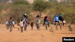 Sudanese families fleeing the conflict in Sudan's Darfur region, make their way through the desert after they crossed the border between Sudan and Chad to seek refuge in Goungour, Chad May 12, 2023.