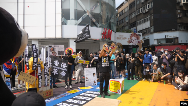 在台流亡港人与香港青年团体等2024年3月23日于台北发起街头集会，以穿插行动剧的方式，谴责当日生效的香港《基本法》第23条 (美国之音特约记者黄丽玲拍摄)。