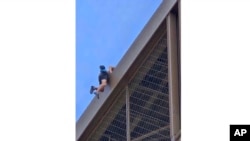 In this photo provided by Nickey Worlock, a man climbs the Eiffel Tower, during the 2024 Summer Olympics, Aug. 11, 2024, in Paris France.